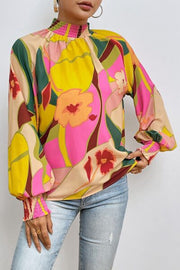 Floral smocked lantern sleeve mock neck blouse.