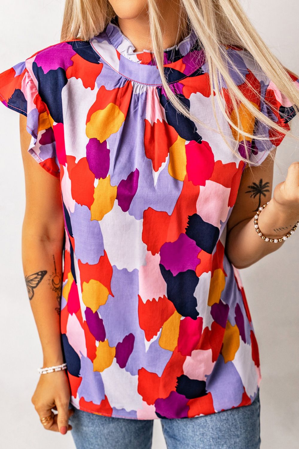 Frill printed mock neck cap sleeve blouse.