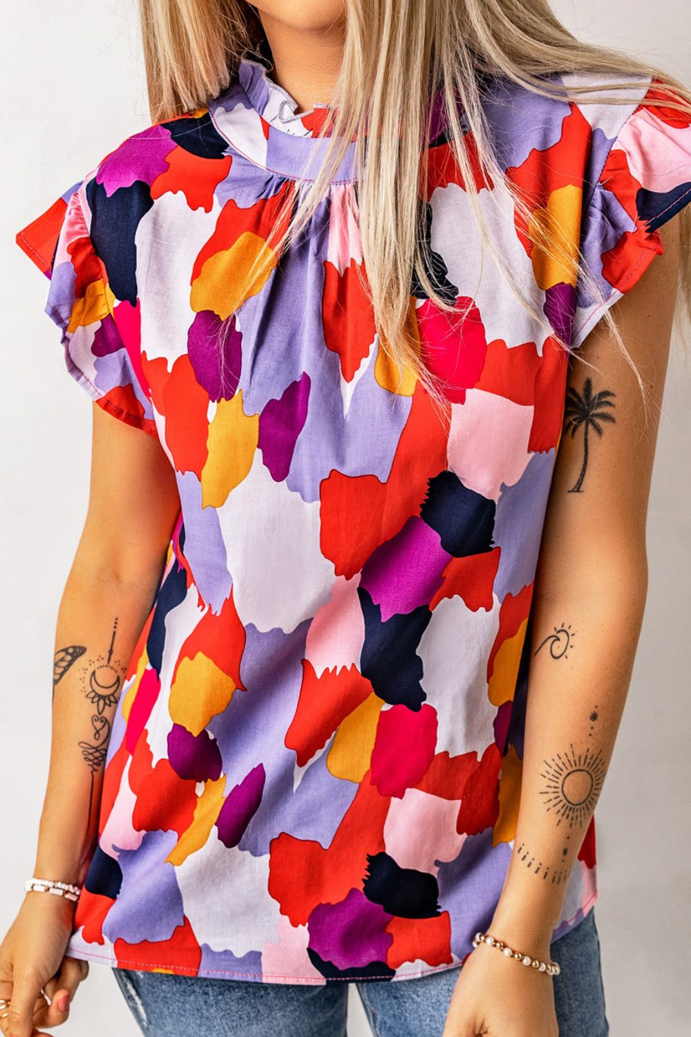 Frill printed mock neck cap sleeve blouse.