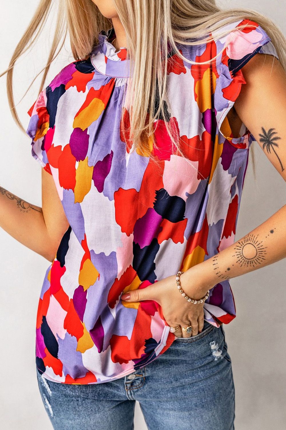 Frill printed mock neck cap sleeve blouse.