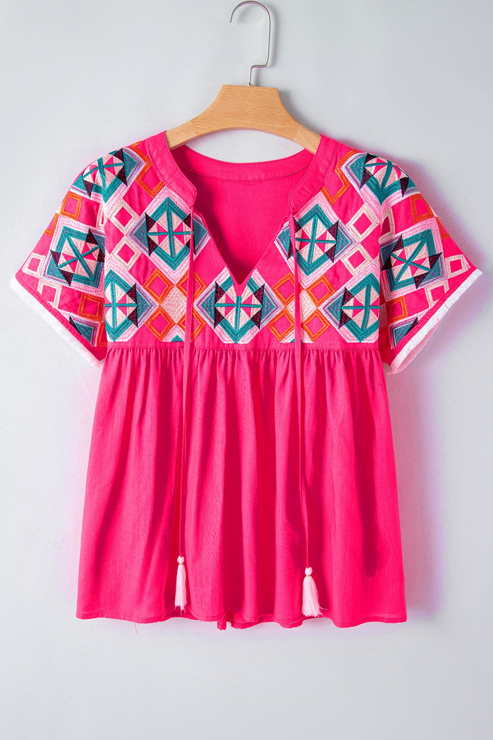 Geometric embroidered tassel tie neck blouse.