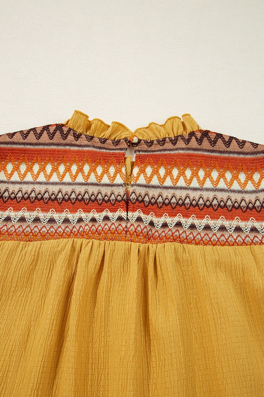 Geometric frill mock neck short sleeve blouse.