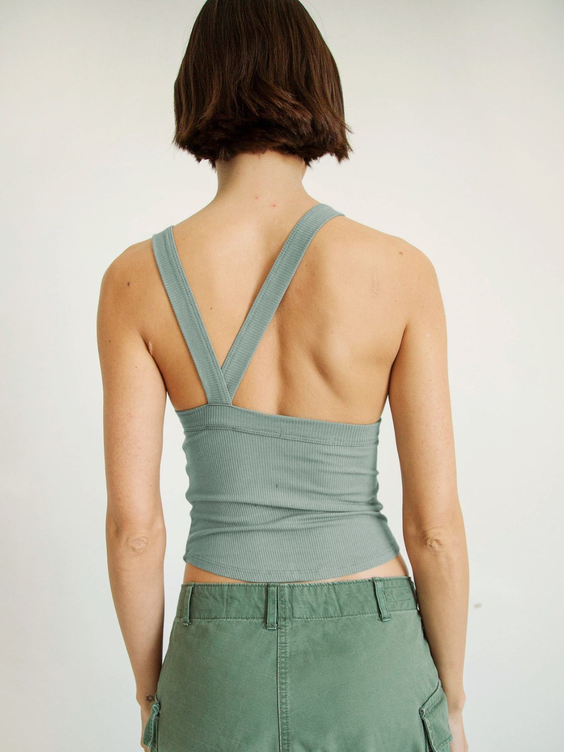 Halter neck ribbed cropped top with backless design.