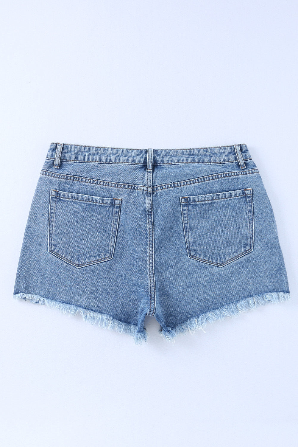 High rise crossover waist denim shorts with buttons, distressed details, and raw hem.