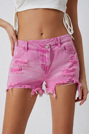 High rise crossover waist denim shorts with buttons, distressed details, and raw hem.