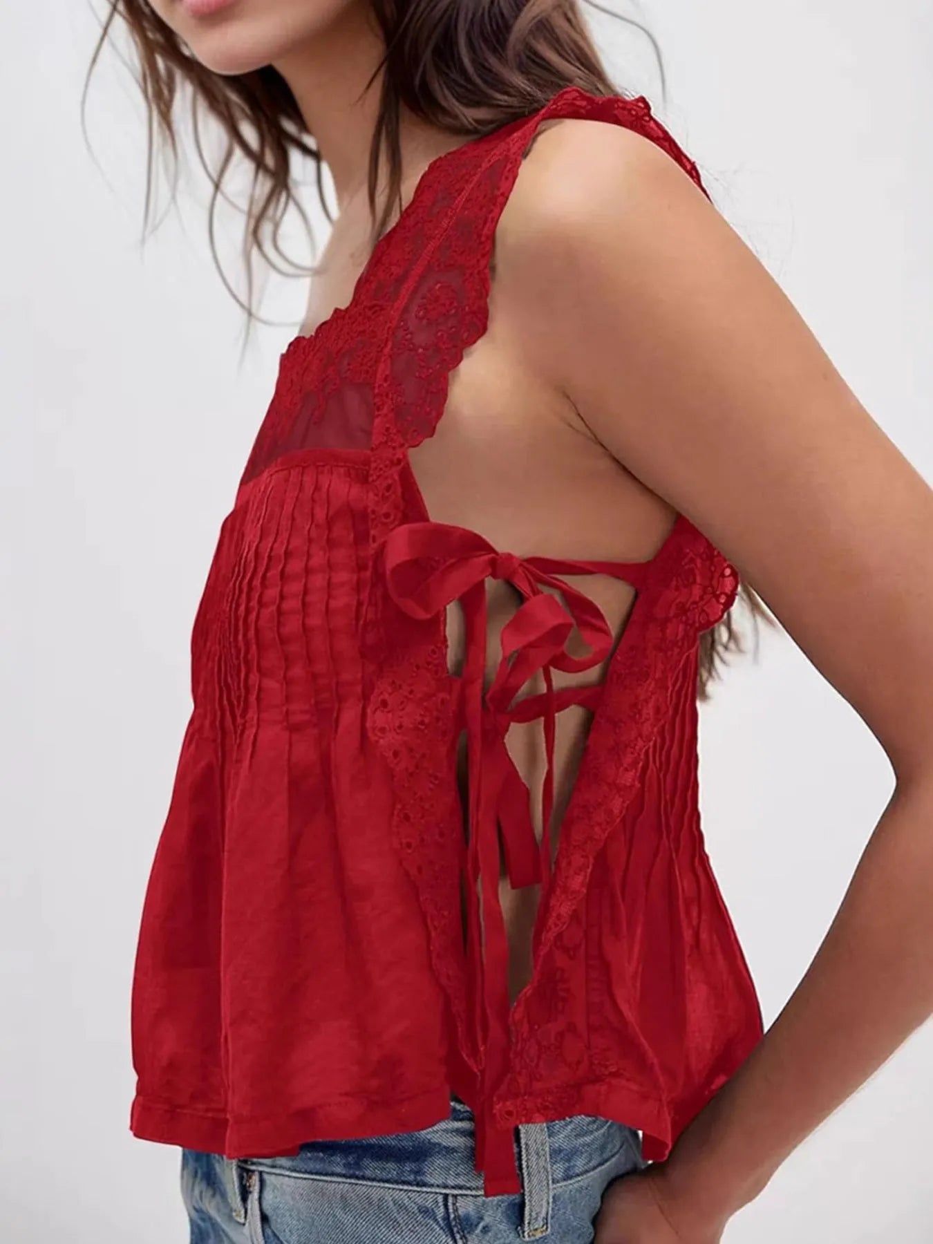 Lace-trimmed eyelet square neck top with tie detail.