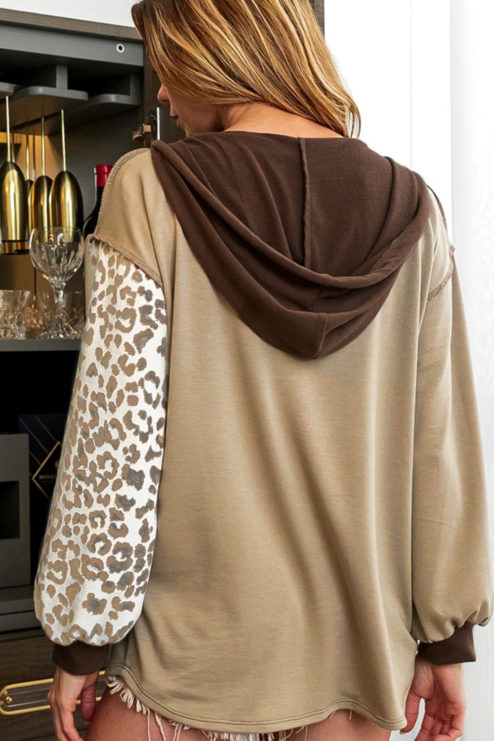 Leopard print drawstring hoodie with a chest pocket and buttons.