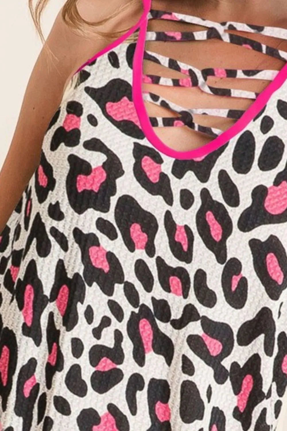 Leopard print caged neck knit camisole with cutout and crisscross details, slightly stretchy.