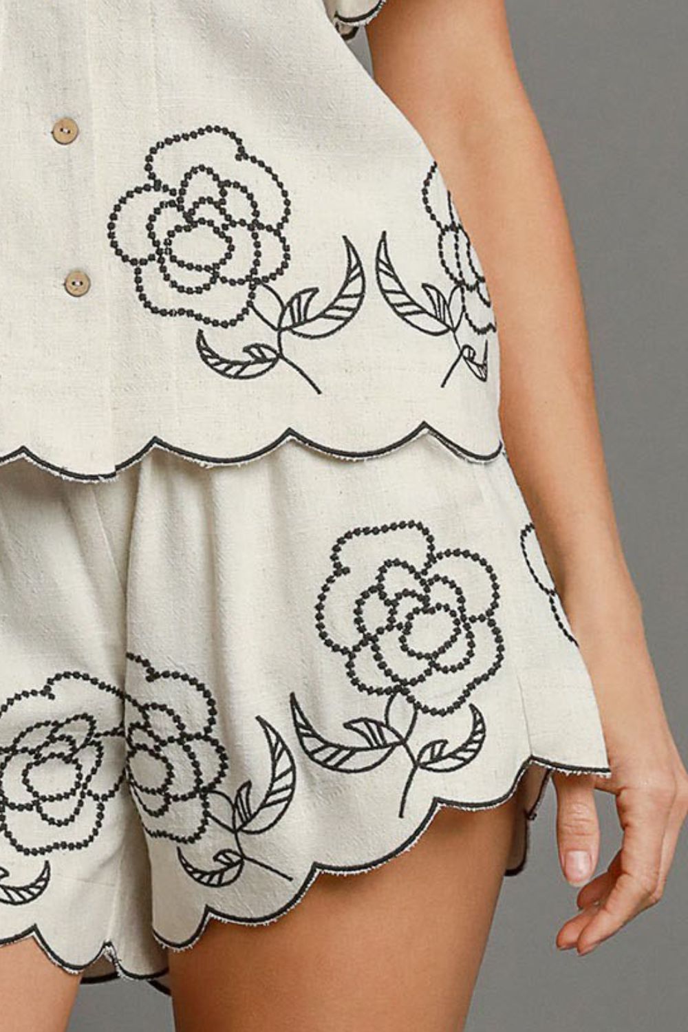 Plus size linen blend shorts with floral embroidered details and pockets.