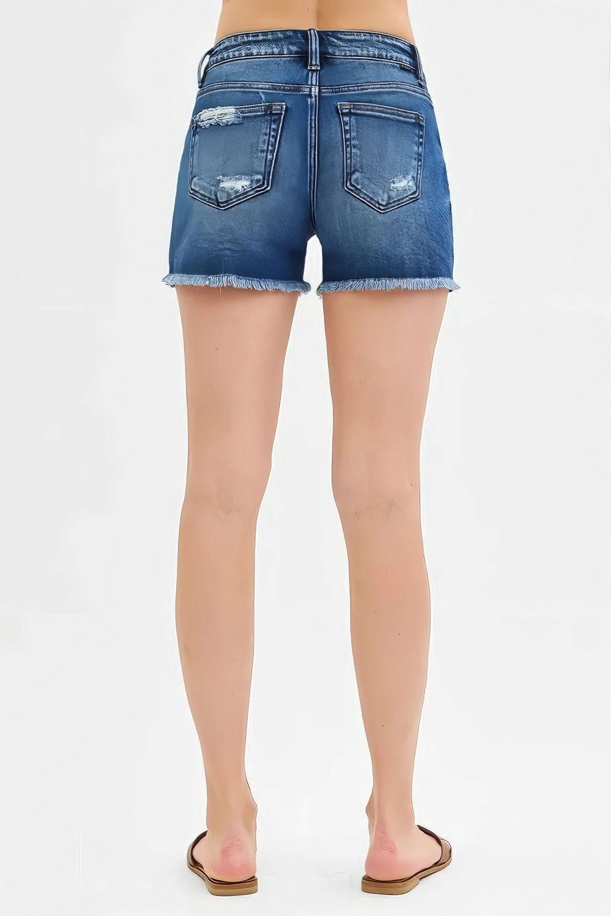 Low rise distressed denim shorts with raw hem and cat's whisker detail.