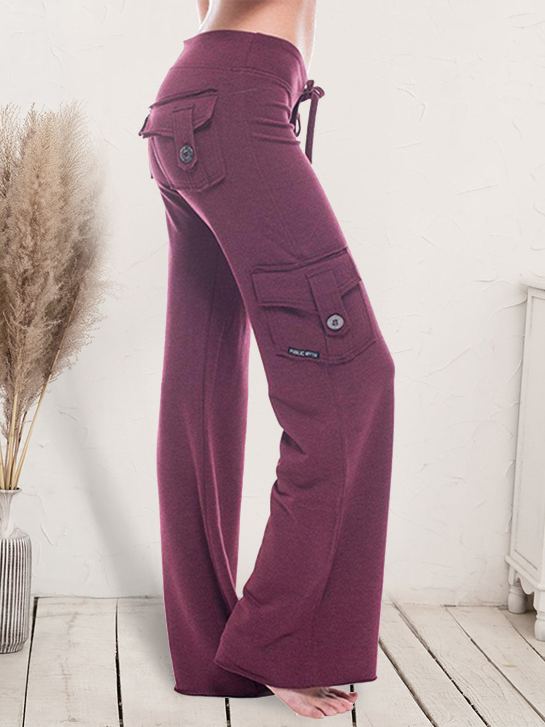 Mid waist pants with drawstring, buttons, and pockets, opaque.