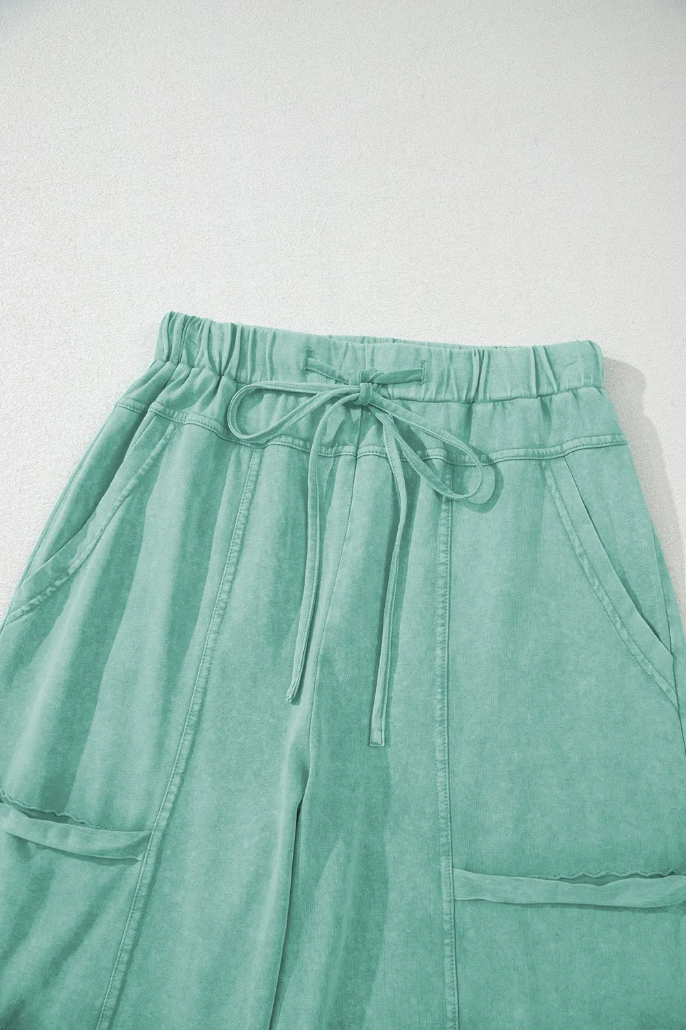 Mineral wash exposed seam drawstring high waist wide leg cargo pants with pockets.