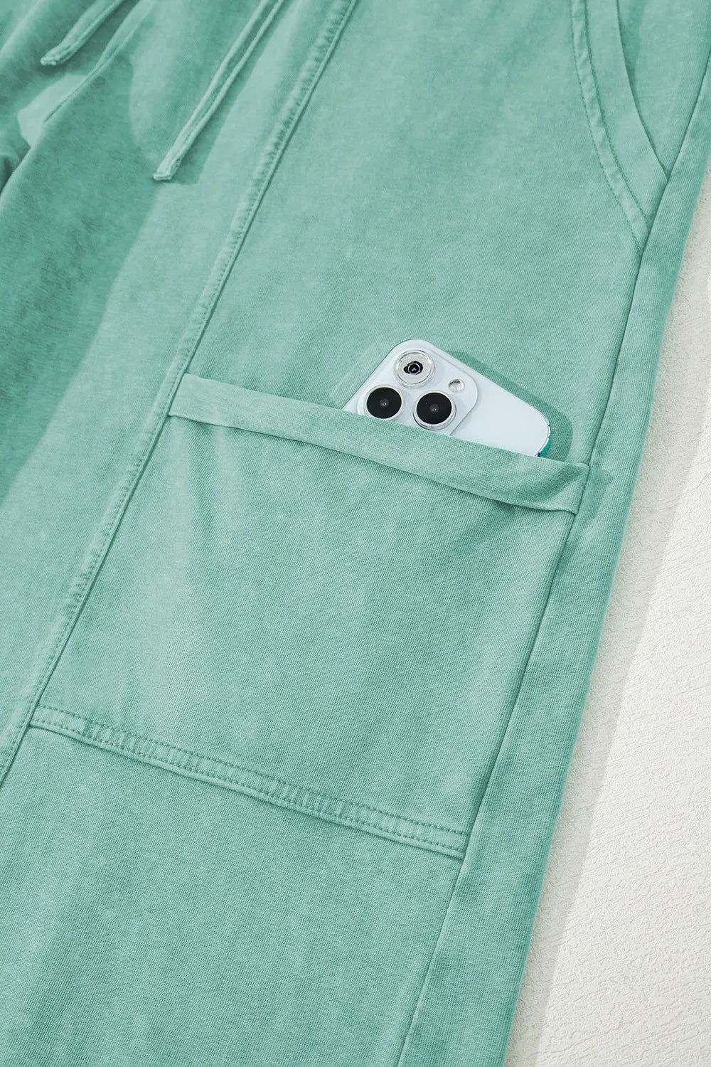 Mineral wash exposed seam drawstring high waist wide leg cargo pants with pockets.