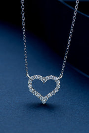 A platinum-plated sterling silver necklace features a delicate chain and sparkling moissanite heart pendant in a polished silver tone.