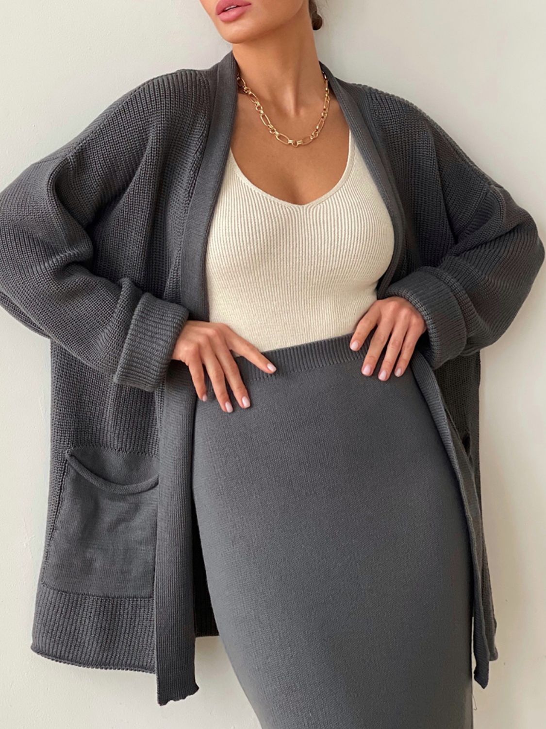Two-piece set: pocketed long sleeve cardigan and matching skirt sweater set.