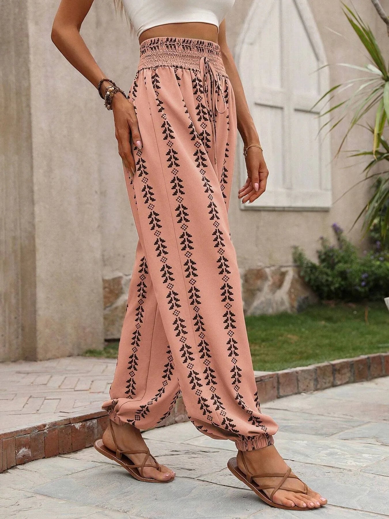 Printed wide leg pants with drawstring, pockets, and smocking.