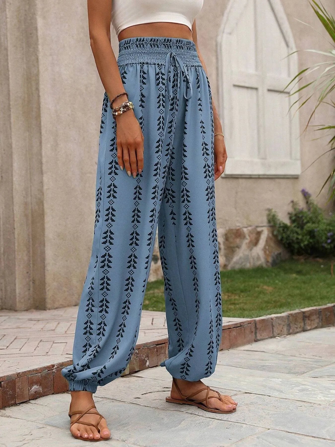 Printed wide leg pants with drawstring, pockets, and smocking.