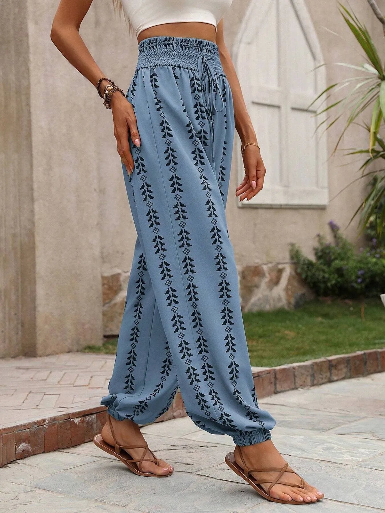 Printed wide leg pants with drawstring, pockets, and smocking.