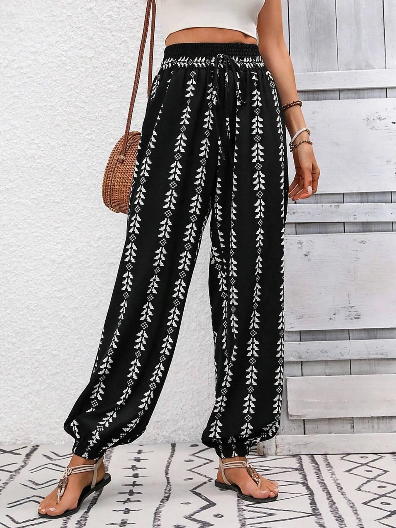 Printed wide leg pants with drawstring, pockets, and smocking.