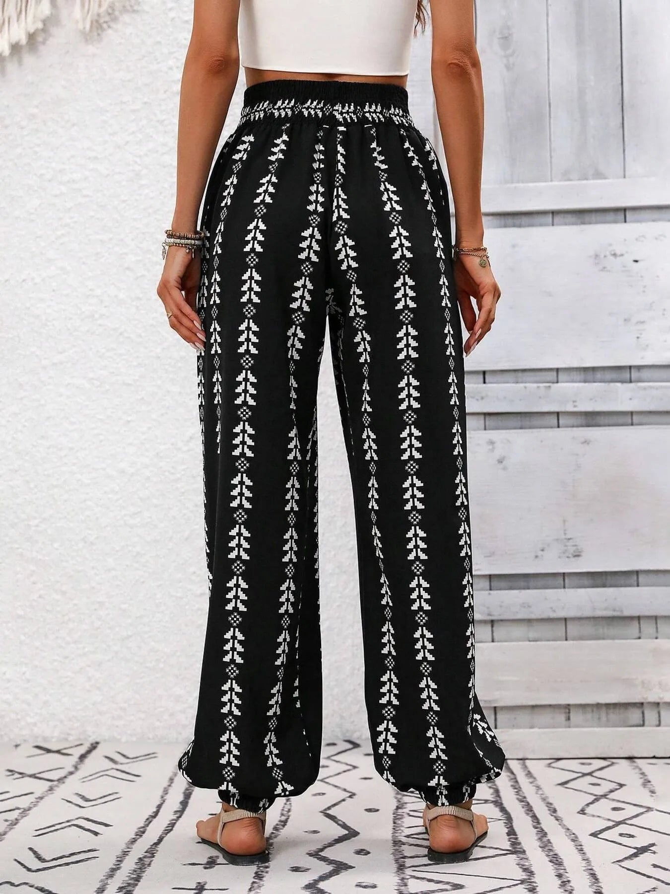 Printed wide leg pants with drawstring, pockets, and smocking.
