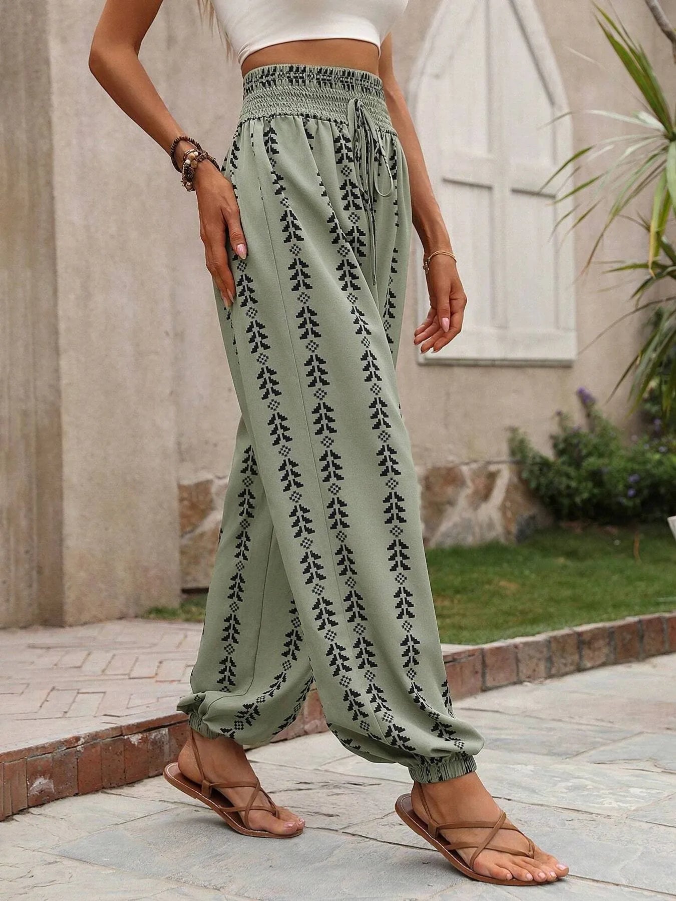 Printed wide leg pants with drawstring, pockets, and smocking.