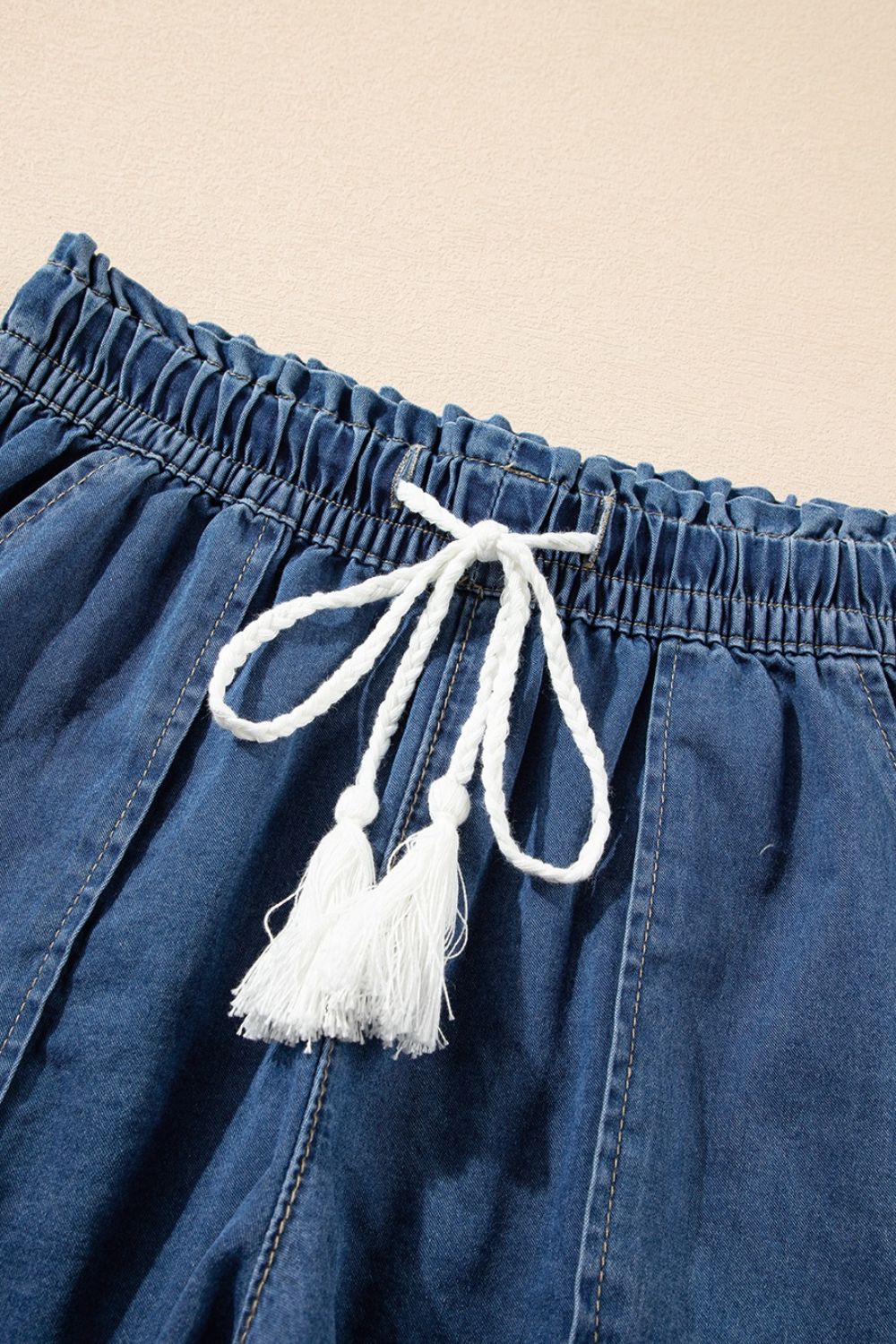 Distressed raw hem denim shorts with buttons and pockets.