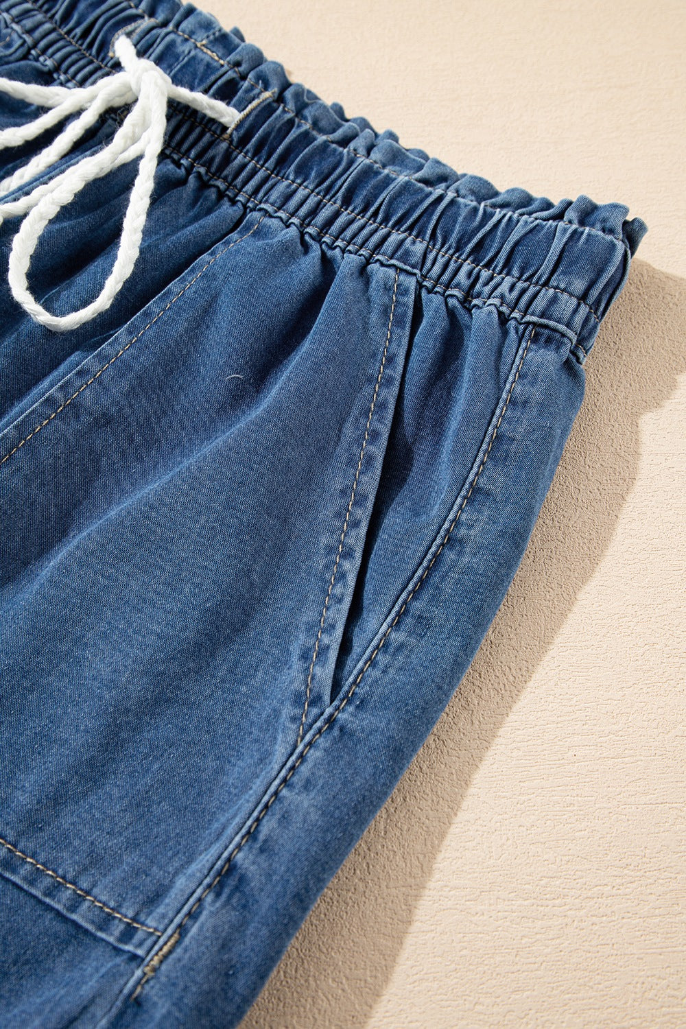 Distressed raw hem denim shorts with buttons and pockets.
