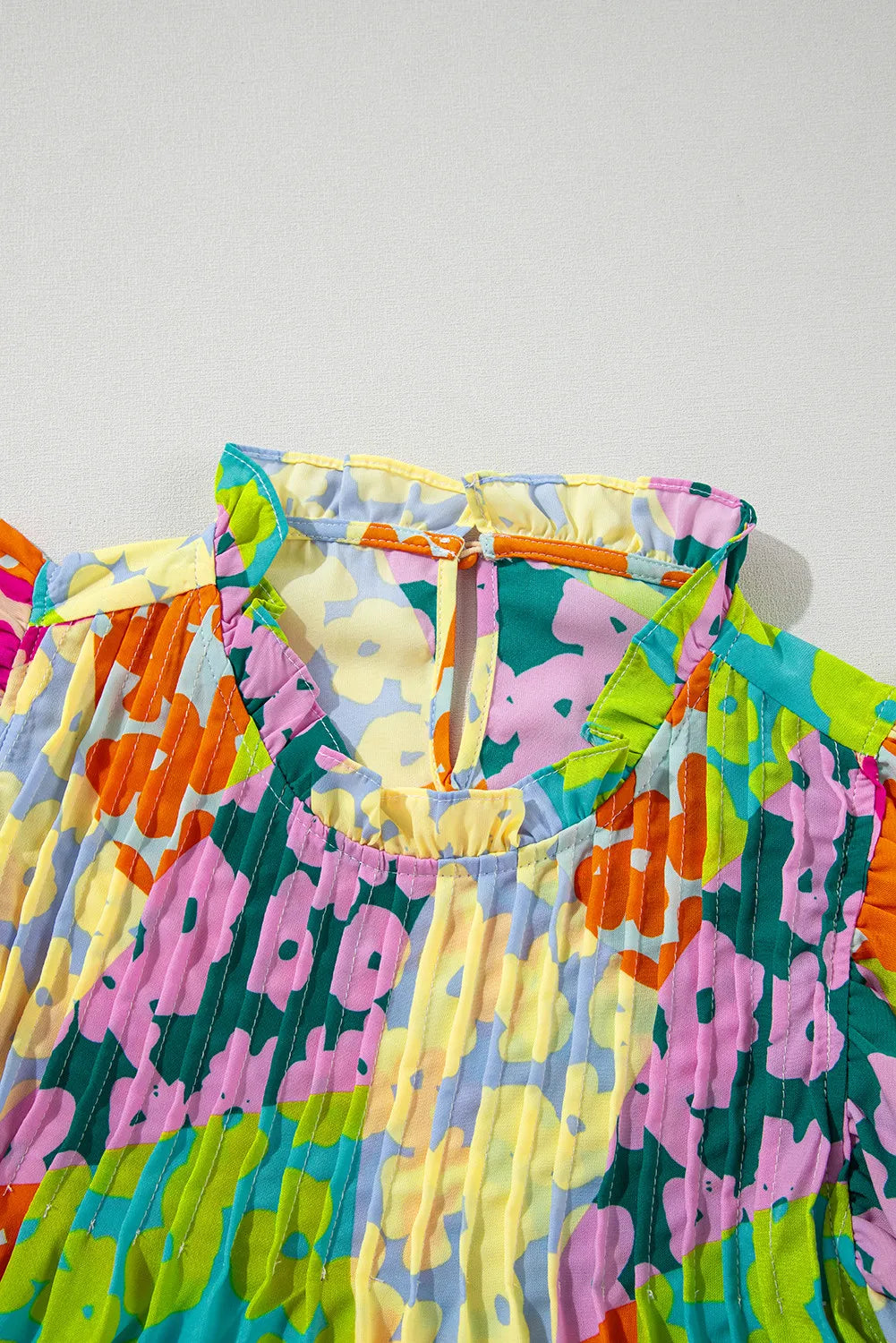 Ruffled Printed Mock Neck Cap Sleeve Blouse.
