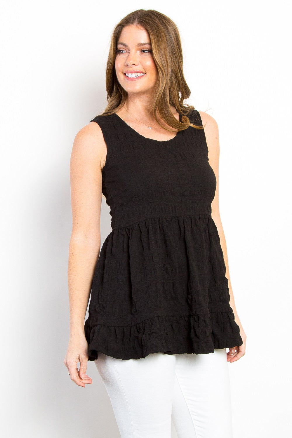 Ruffled sleeveless babydoll top with peplum and ruched details, opaque and slightly stretchy.