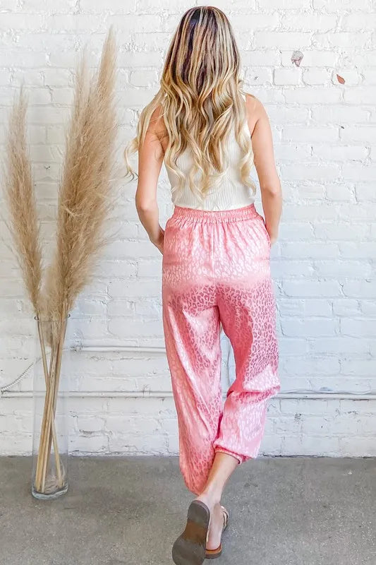 Satin leopard print joggers with drawstring and pockets.