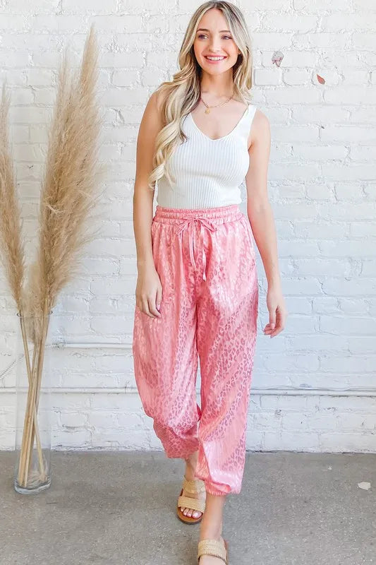 Satin leopard print joggers with drawstring and pockets.