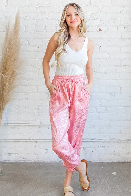 Satin leopard print joggers with drawstring and pockets.