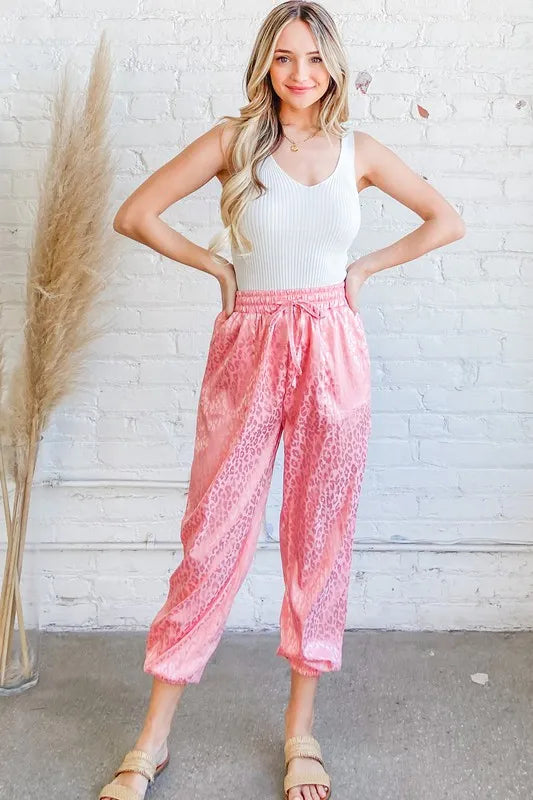 Satin leopard print joggers with drawstring and pockets.