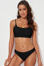 Solid scoop neck sleeveless swim set with high-cut bottoms and ruched details.