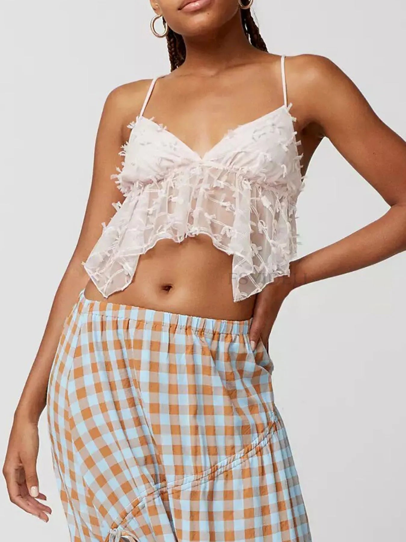 Sheer lace cami top with delicate trim and tie detail.