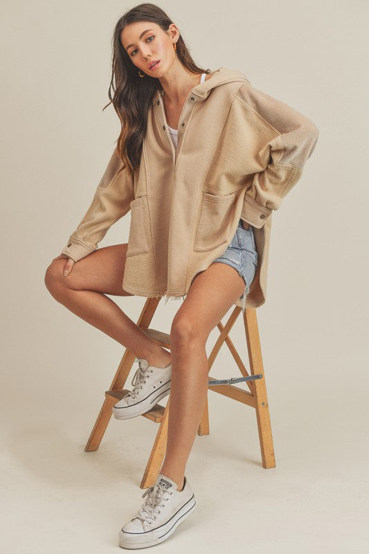 Slit half snap oversize hoodie with ribbed raw hem and pockets.