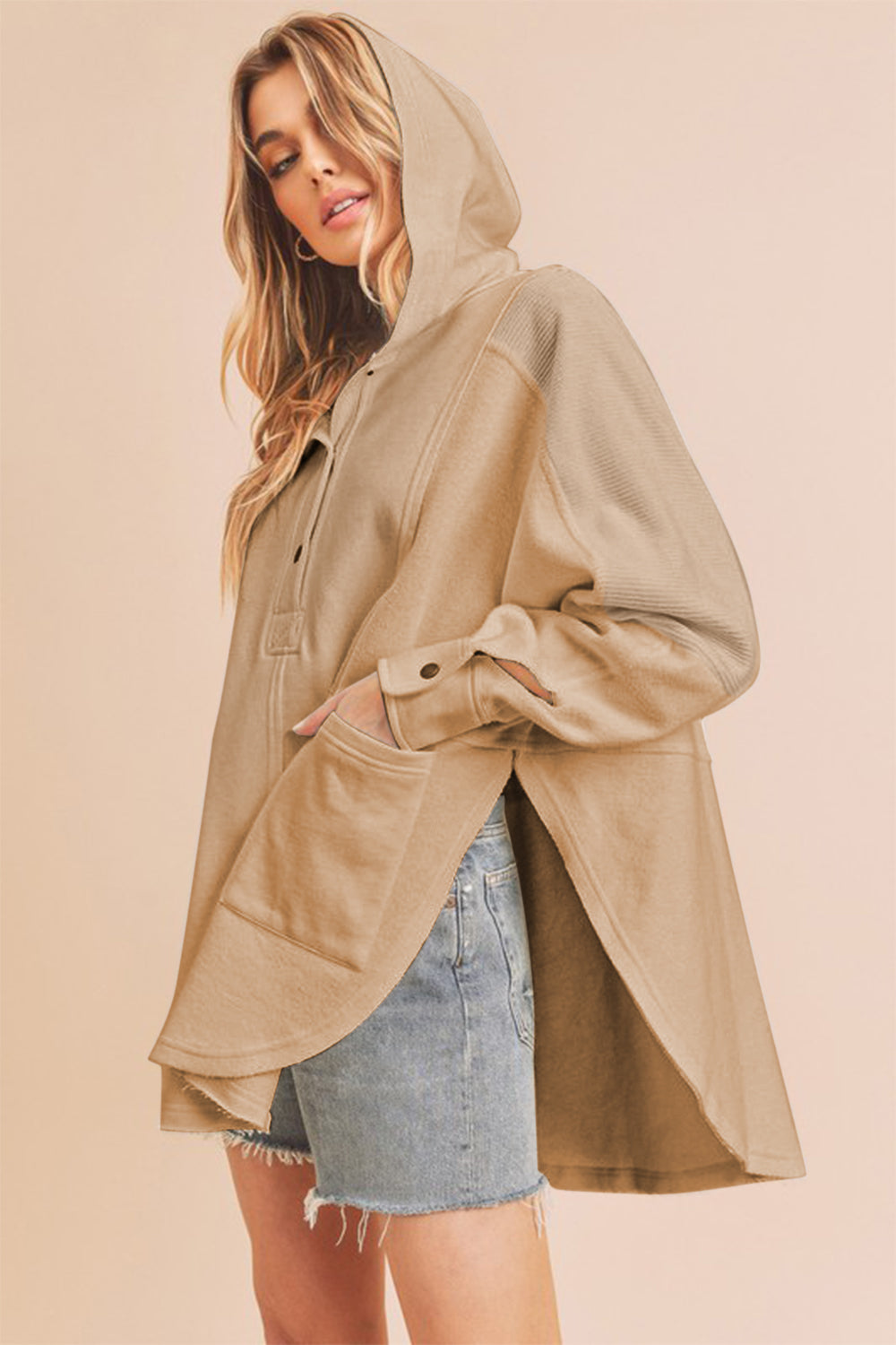 Slit half snap oversize hoodie with ribbed raw hem and pockets.