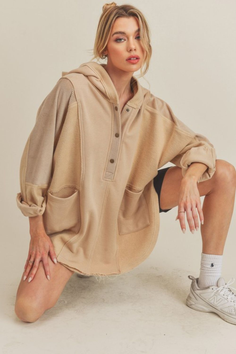 Slit half snap oversize hoodie with ribbed raw hem and pockets.