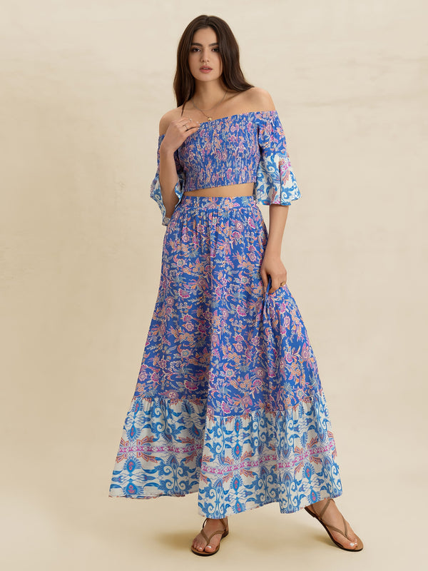 Woman wearing a blue floral off-shoulder dress on a beige background