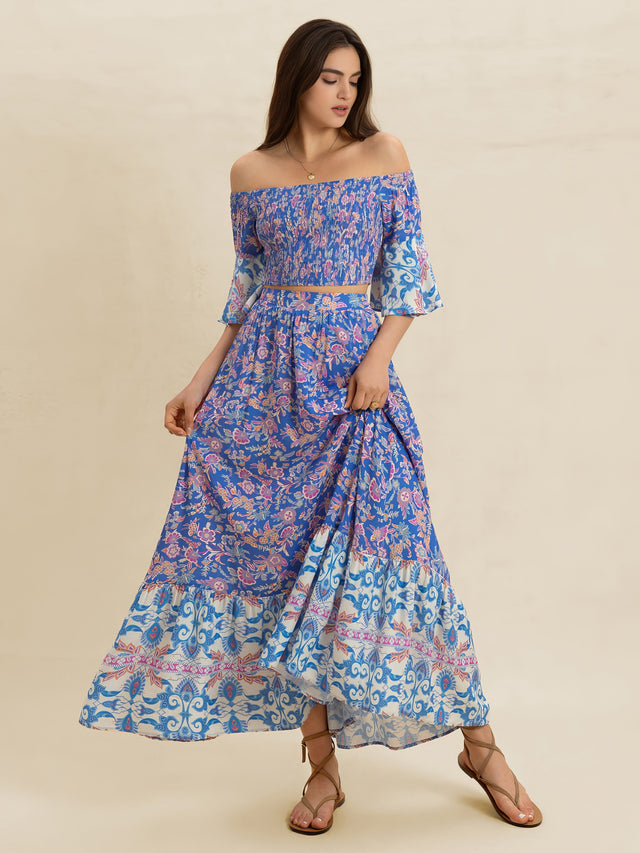 Woman wearing a blue floral off-shoulder dress on a beige background