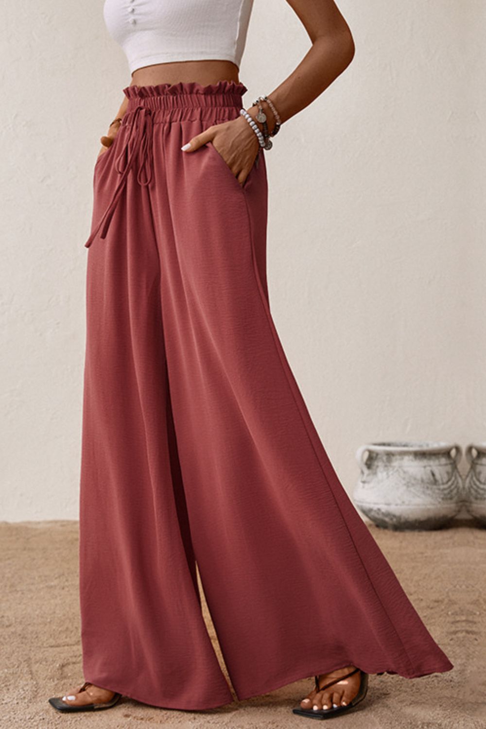 Smocked paperbag waist wide leg pants with tie and frill, casual style.