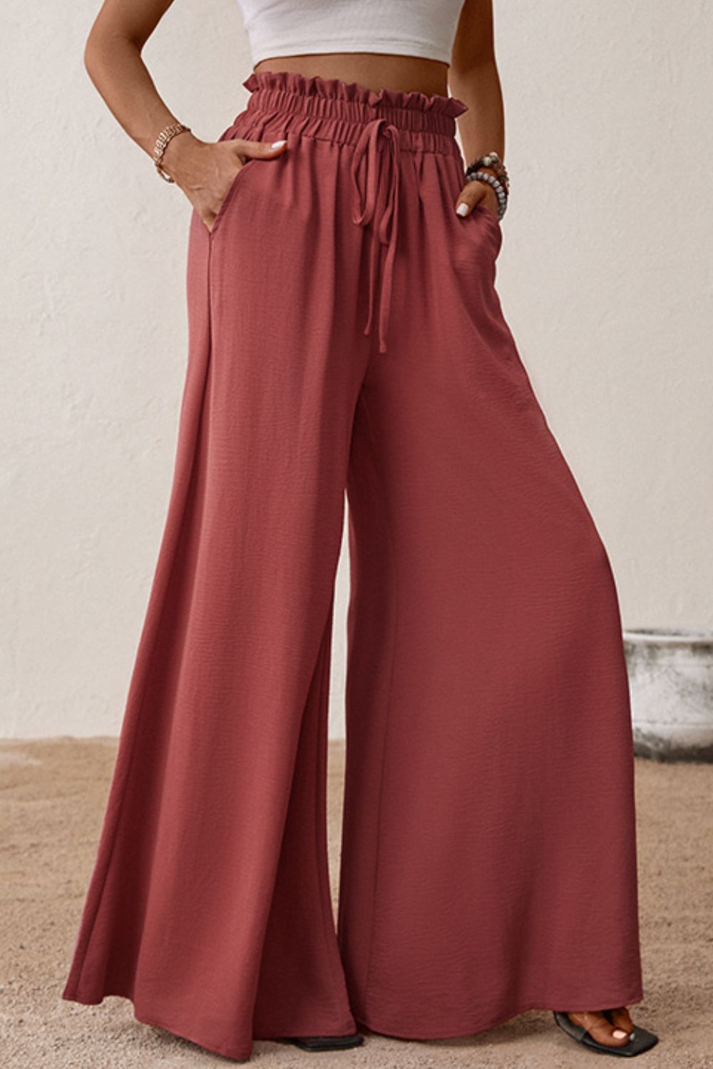 Smocked paperbag waist wide leg pants with tie and frill, casual style.