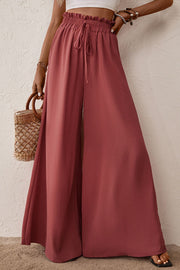 Smocked paperbag waist wide leg pants with tie and frill, casual style.