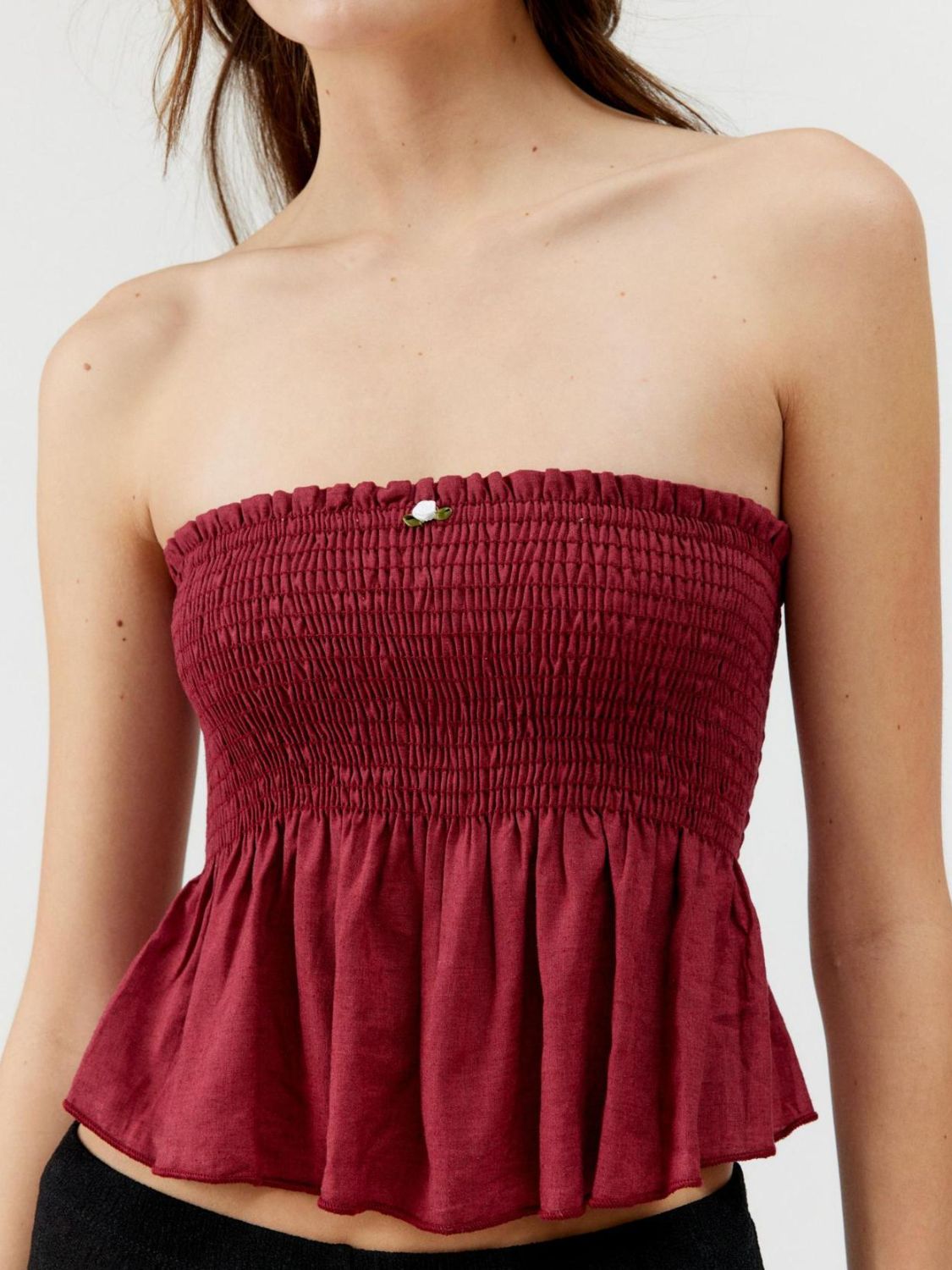 Smocked peplum tube top with ruched and ruffled details, slightly stretchy.