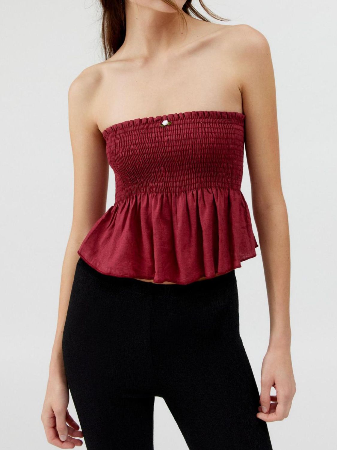 Smocked peplum tube top with ruched and ruffled details, slightly stretchy.