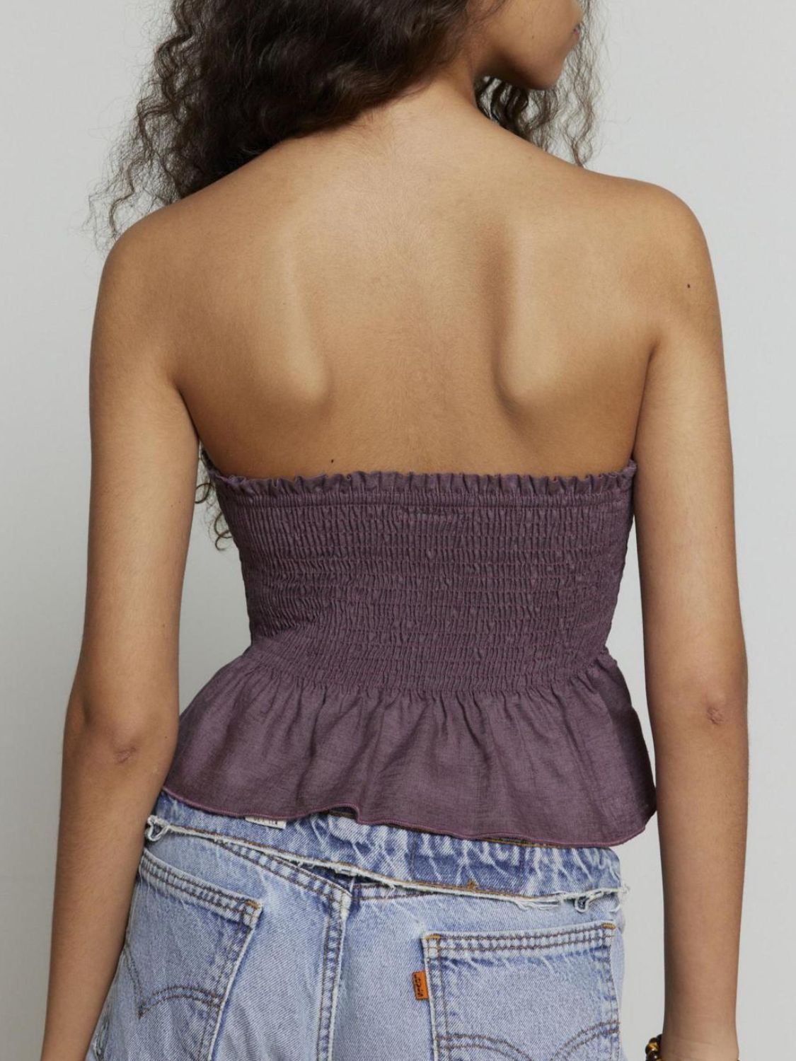 Smocked peplum tube top with ruched and ruffled details, slightly stretchy.