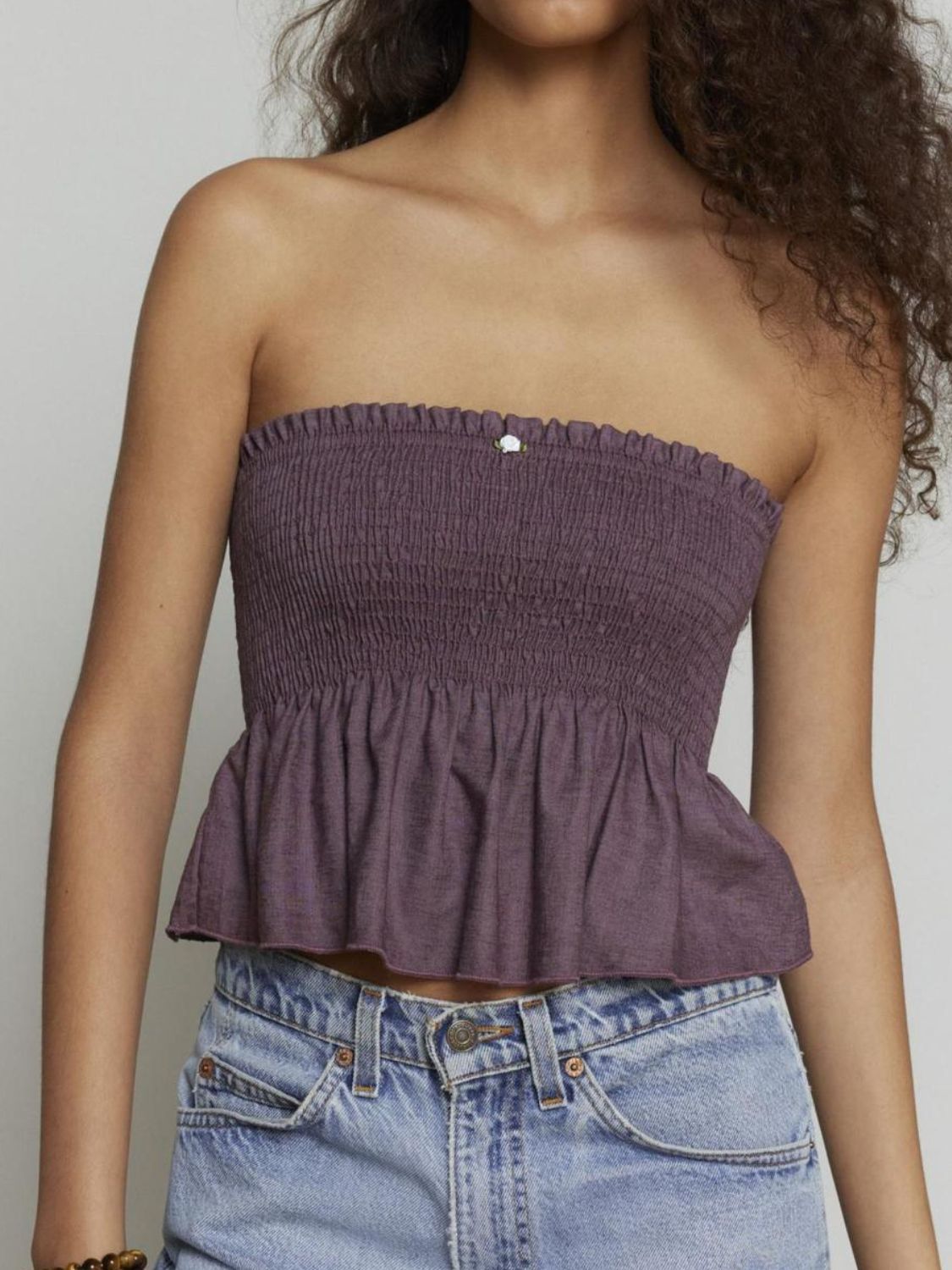 Smocked peplum tube top with ruched and ruffled details, slightly stretchy.