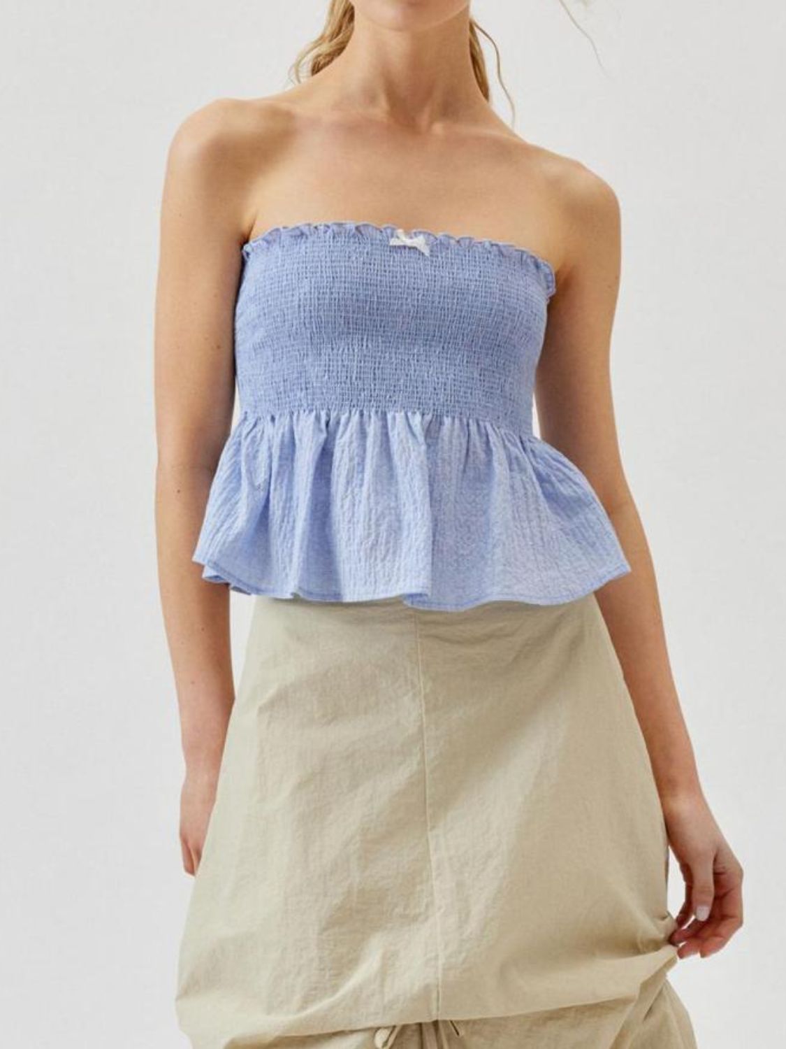 Smocked peplum tube top with ruched and ruffled details, slightly stretchy.