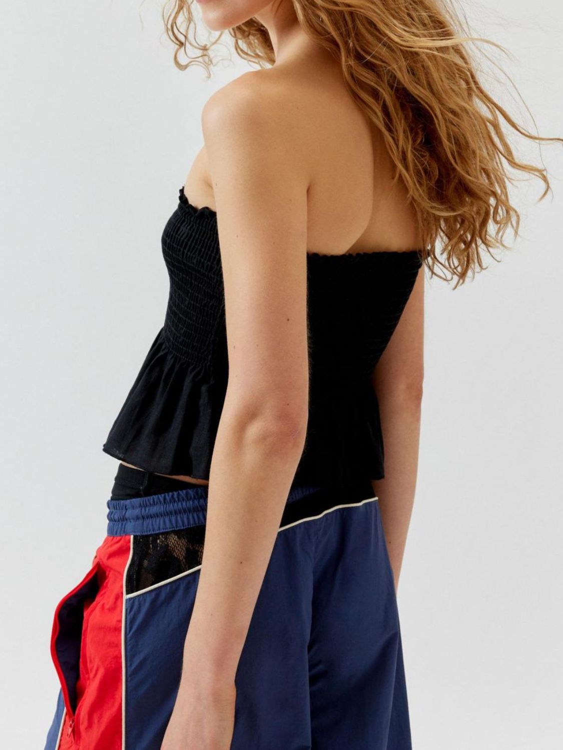 Smocked peplum tube top with ruched and ruffled details, slightly stretchy.