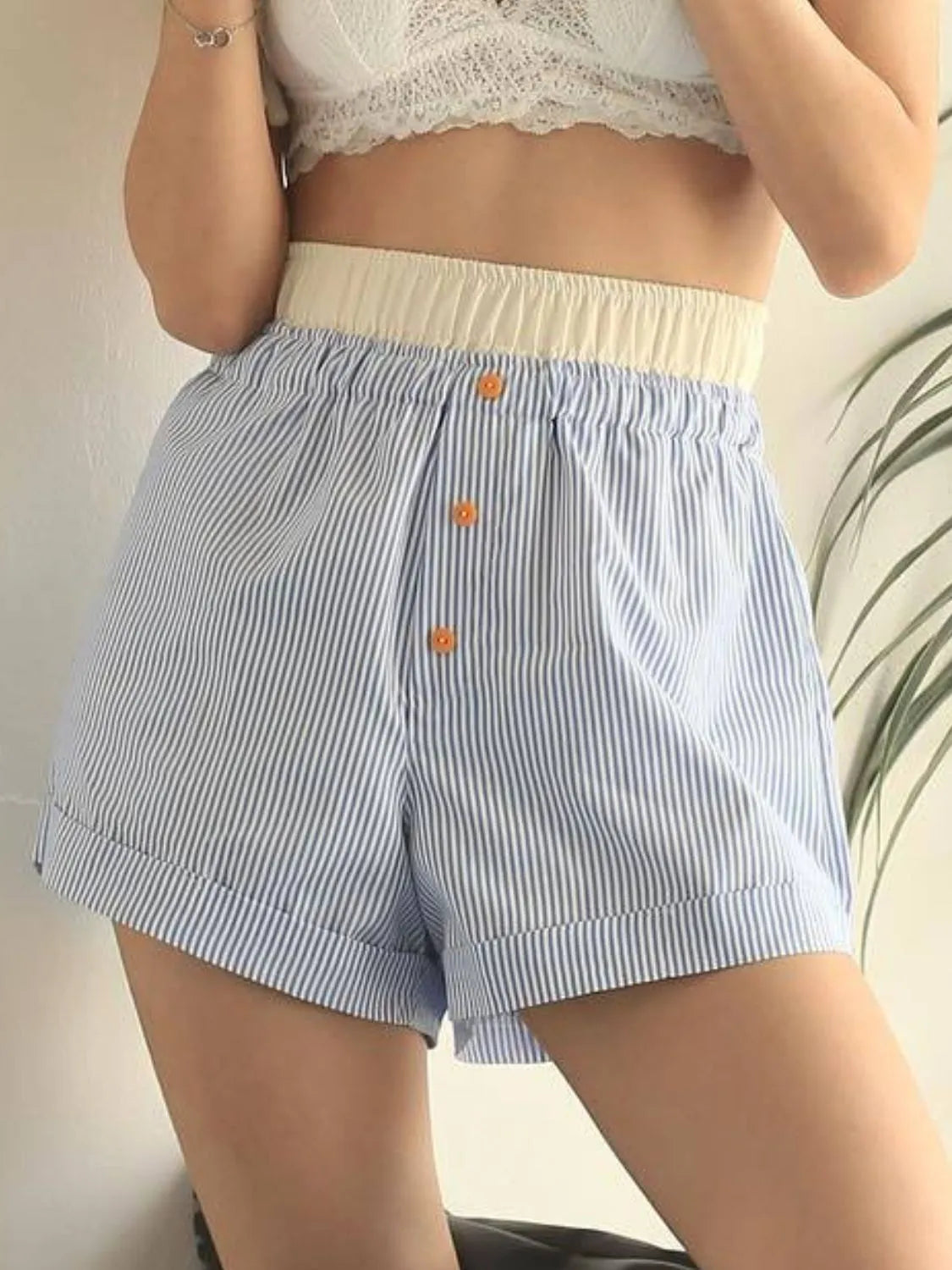 High-waist denim shorts with buttons and pockets.